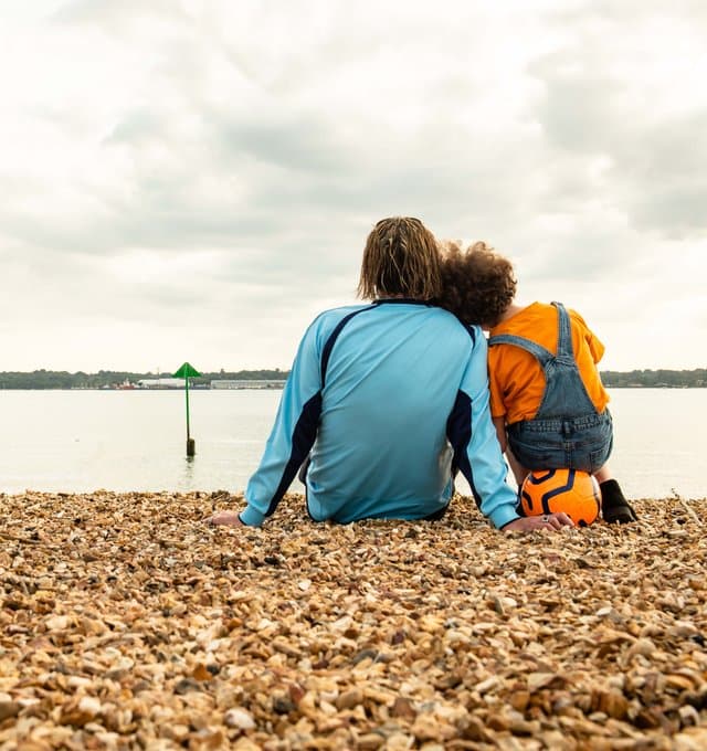 Two people sat on the beach