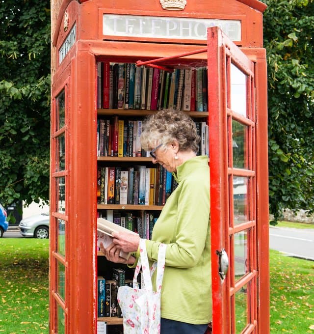 Women in bookshop telephone box